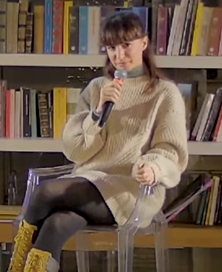 Andrea Delogu con il microfono durante un incontro al Circolo dei lettori, seduta davanti a una libreria nel marzo 2024