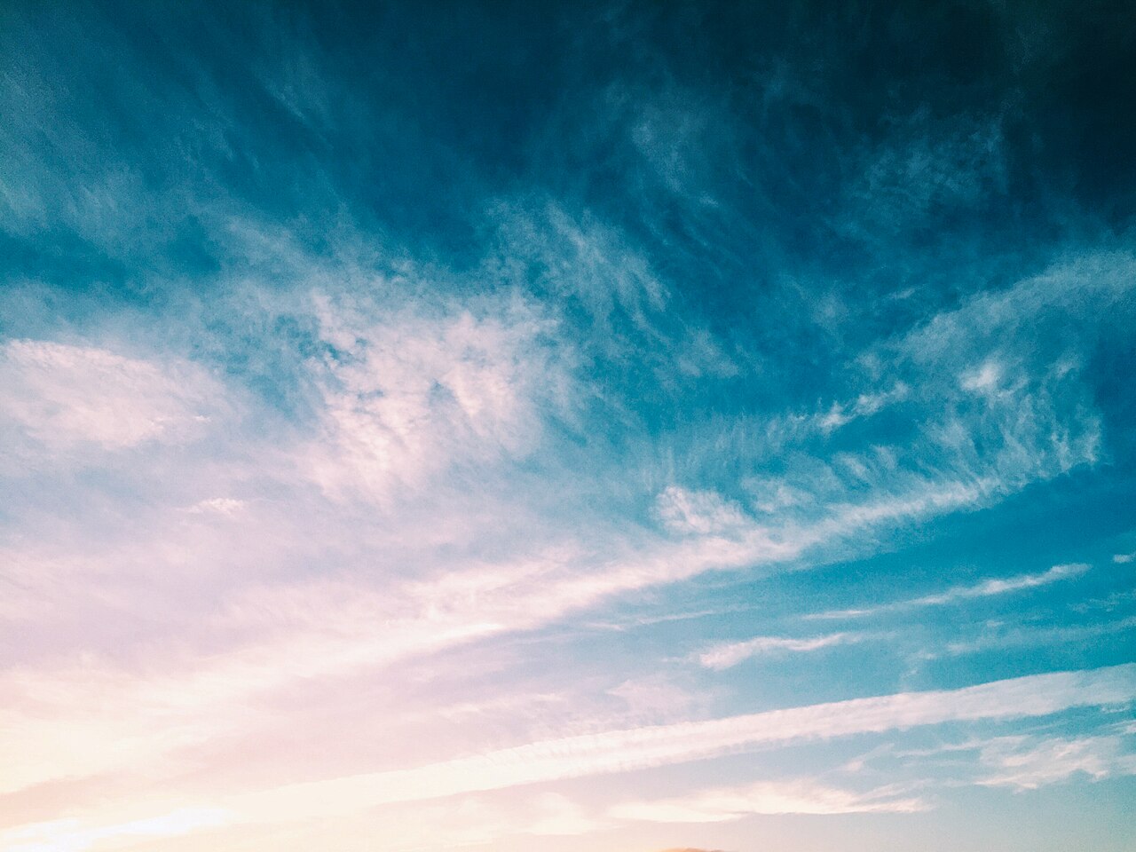 Cielo azzurro attraversato da sottili nuvole bianche illuminate dal Sole